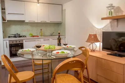 a kitchen with a glass table and chairs and a television at Navona White Apartment in Rome