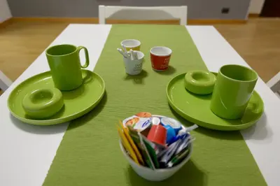 a table with green plates and cups on it at Oasi Del Vaticano in Rome