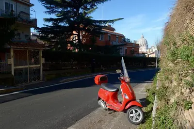 a red scooter parked on the side of a street at Oasi Del Vaticano in Rome
