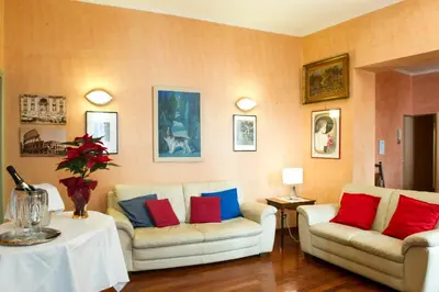 a living room with two white couches and colorful pillows at GREGORIANA HOUSE - Appartamento con Vista su Roma in Rome