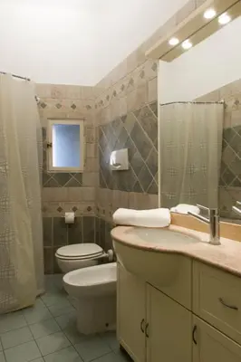 a bathroom with a toilet and a sink and a mirror at GREGORIANA HOUSE - Appartamento con Vista su Roma in Rome