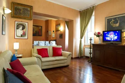 a living room with a couch and a tv at GREGORIANA HOUSE - Appartamento con Vista su Roma in Rome