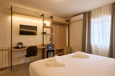 a hotel room with a bed and a desk and a window at Relais Tiburtina in Rome