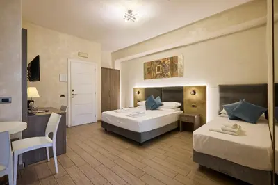 a hotel room with two beds and a table at Relais Tiburtina in Rome