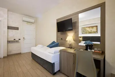 a hotel room with a bed and a desk with a television at Relais Tiburtina in Rome