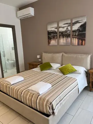 a bedroom with a large bed with three paintings on the wall at Casette Romane 