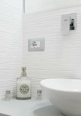 a white bathroom with a sink and a bottle of soap at Casette Romane 