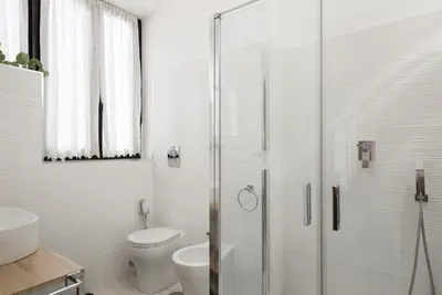 a bathroom with a toilet and a glass shower at Casette Romane 
