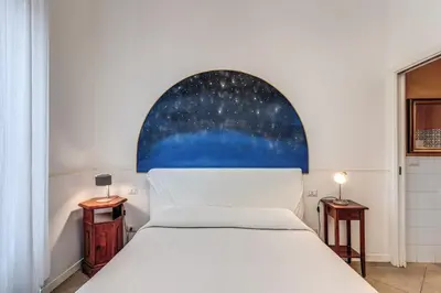 a bedroom with a white bed and an arched window at Bless&B G.H. in Rome