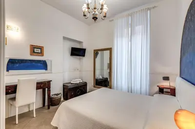 a bedroom with a bed and a desk and a mirror at Bless&B G.H. in Rome