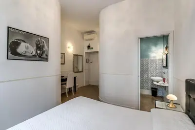 a white room with a bed and a table at Bless&B G.H. in Rome