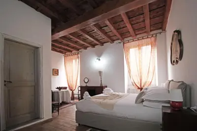 a bedroom with a large bed and two windows at Monti Bespoke in Rome