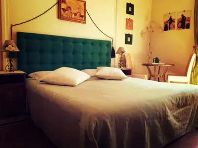 a bedroom with a large bed with a green headboard at B&B DolceVirginia in Rome