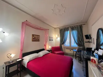 a bedroom with a red bed and a red chair at B&B DolceVirginia in Rome