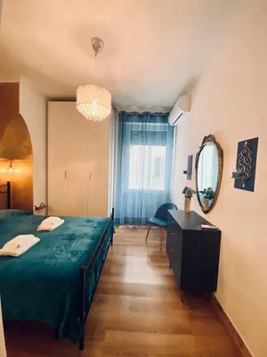 a bedroom with a green bed and a mirror at GuestART Monti Apartment in Rome