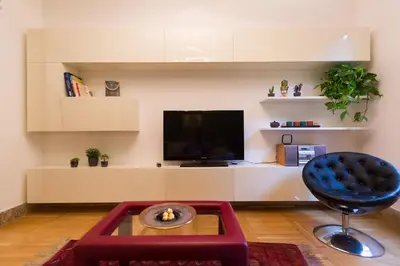 a living room with a tv and a blue chair at GuestART Monti Apartment in Rome