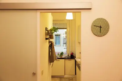 an open door to a kitchen with a clock on the wall at GuestART Monti Apartment in Rome