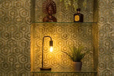 a lamp on a wall with a statue on a shelf at GuestART Monti Apartment in Rome