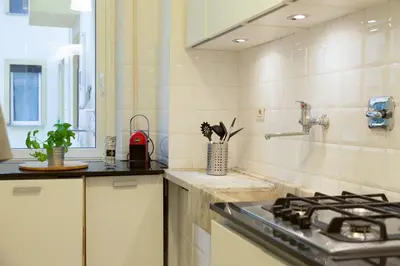 a kitchen with a stove and a sink at GuestART Monti Apartment in Rome