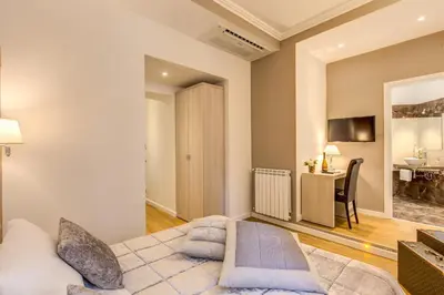 a bedroom with a king sized bed and a desk at The Bridge Suites in Rome