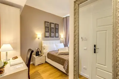 a bedroom with a bed and a mirror at The Bridge Suites in Rome