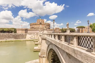a bridge over a river with a building in the background at The Bridge Suites in Rome