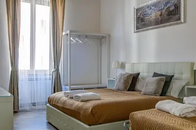a bedroom with two beds and a large window at St. Peter Vatican Apartment in Rome