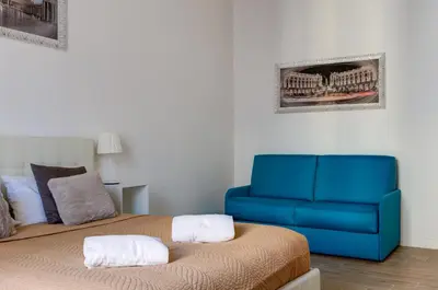 a bedroom with a bed and a blue couch at St. Peter Vatican Apartment in Rome