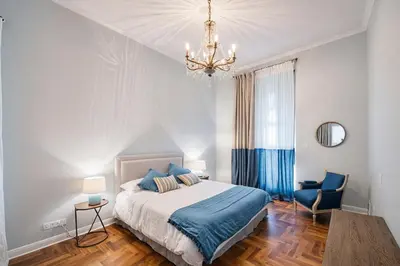 a bedroom with a bed and a chandelier at Carducci Luxury Apartment in Rome