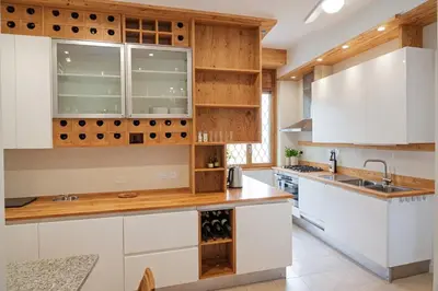 a kitchen with white cabinets and wooden counters at Carducci Luxury Apartment in Rome