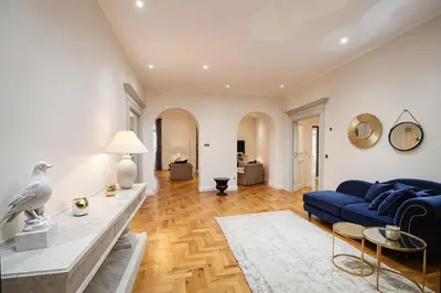 a living room with a blue couch and a table at Carducci Luxury Apartment in Rome