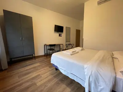 a bedroom with a white bed and a tv at Luciano Licia Guest House in Rome