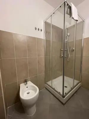a bathroom with a toilet and a glass shower at Luciano Licia Guest House in Rome