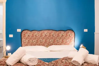 a blue room with a bed with towels on it at Colosseum B in Rome