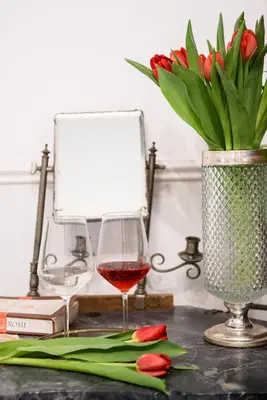 a table with a glass of wine and a vase of flowers at Colosseum B in Rome
