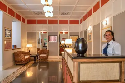 a man standing behind a bar in a hotel lobby at Albergo Etico Roma in Rome