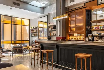 a restaurant with a bar with wooden stools at Albergo Etico Roma in Rome