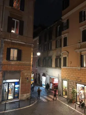 a group of people walking down a street at night at 