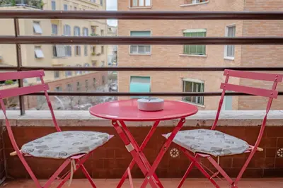 a red table and two chairs on a balcony at Damiani & Sister Guesthouse in Rome