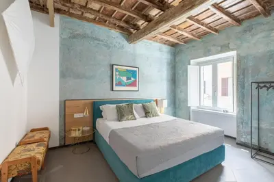 a bedroom with a bed in a room with blue walls at iFlat Vatican High-End Apartment in Rome