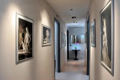 a hallway with framed art on the walls at B&B Best Vatican in Rome