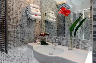 a bathroom with a sink and a vase with a red flower at B&B Best Vatican in Rome