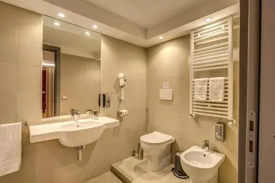 a bathroom with a sink and a toilet and a mirror at HiSuiteROME - ApartHotel in Rome
