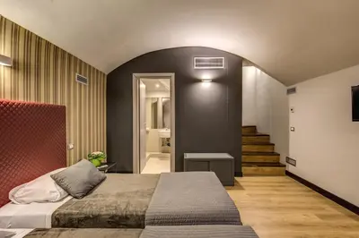a bedroom with a bed and a hallway with stairs at HiSuiteROME - ApartHotel in Rome