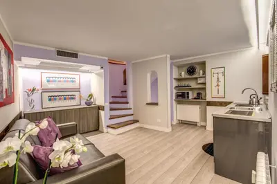 a living room with a couch and a kitchen at HiSuiteROME - ApartHotel in Rome