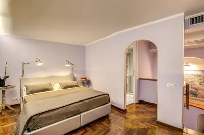 a bedroom with a large bed and a table at HiSuiteROME - ApartHotel in Rome