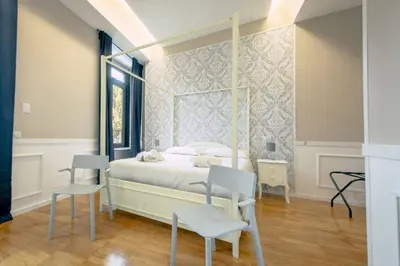 a bedroom with a canopy bed with two chairs at Trastevere Glasshouse in Rome