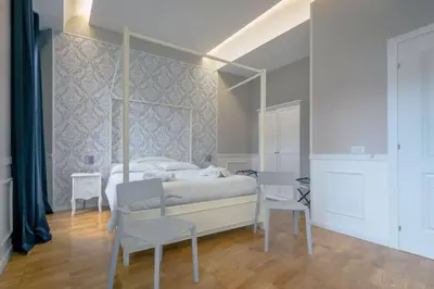 a bedroom with a canopy bed and two chairs at Trastevere Glasshouse in Rome