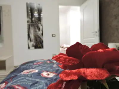 a red stuffed flower sitting on top of a bed at Domus Angelica in Rome