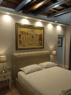 a bedroom with a bed with a picture on the wall at Fontana Di Trevi - Central Apartment in Rome in Rome